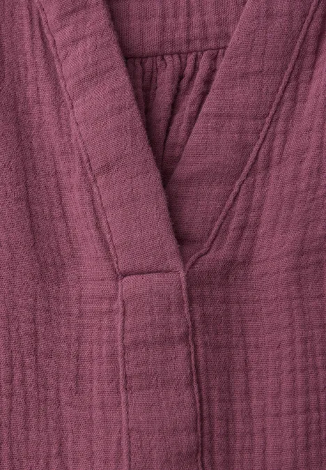 Nahaufnahme eines purpurfarbenen, leicht gesteppten Kimono-ähnlichen Bademantels aus Baumwollstoff.